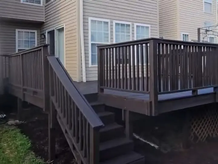 Restored two-story deck with rebuilt stairs and code-height railings after damaged boards were replaced